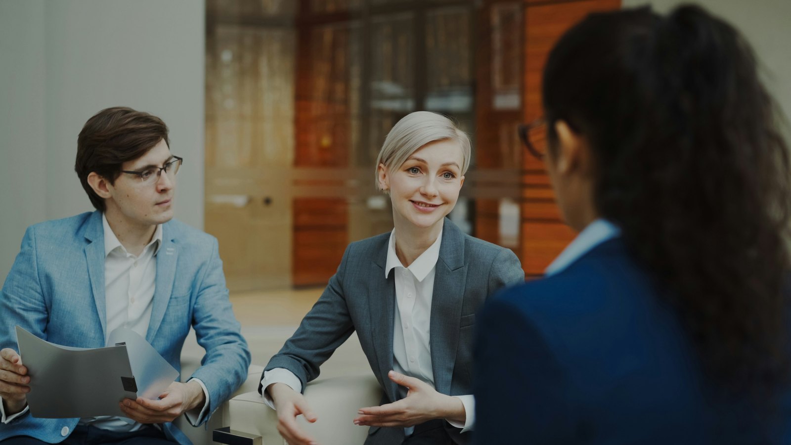 Business professionals discussing documents in a modern office.